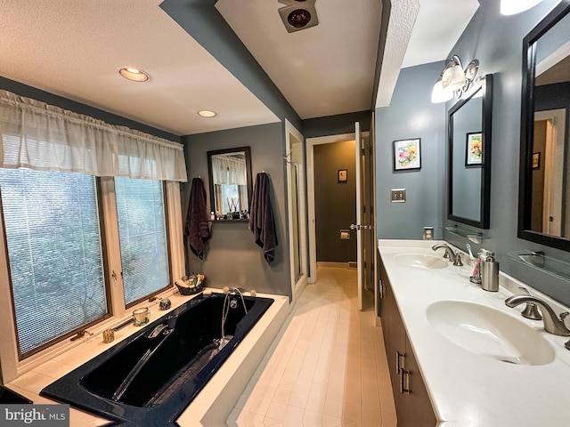 bathroom with a garden tub, double vanity, a sink, and a shower stall