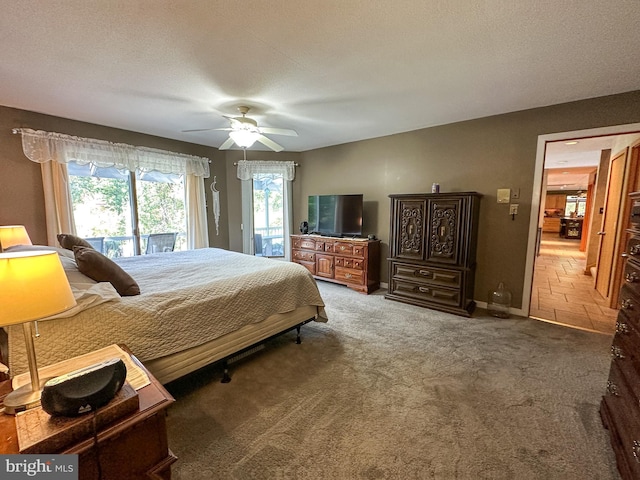 carpeted bedroom with access to outside, baseboards, ceiling fan, and a textured ceiling