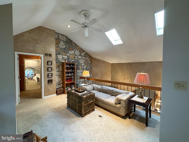 living area featuring carpet floors, a skylight, visible vents, ceiling fan, and high vaulted ceiling