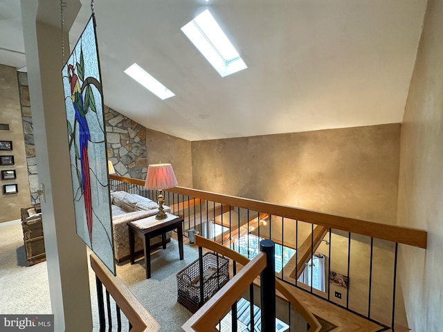 staircase with carpet floors and lofted ceiling with skylight