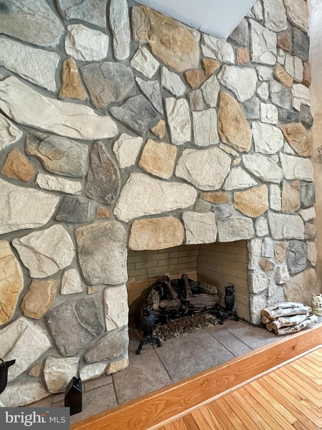 room details with a large fireplace and wood finished floors