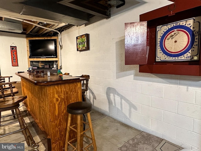 bar with a dry bar and concrete floors