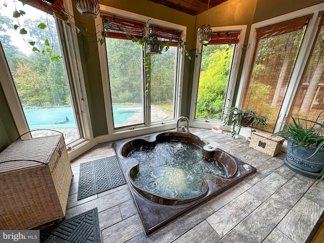 sunroom / solarium with lofted ceiling, visible vents, and a hot tub