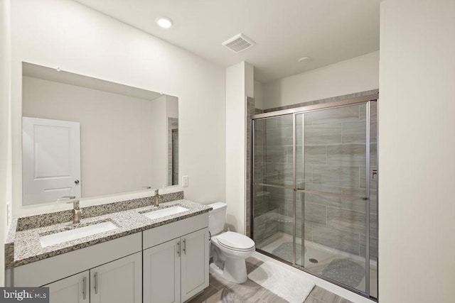 bathroom with a stall shower, visible vents, and a sink