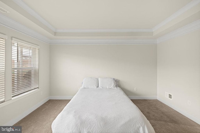 carpeted bedroom featuring visible vents, baseboards, and crown molding