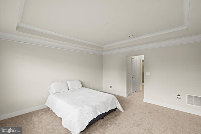 bedroom featuring visible vents, a tray ceiling, and light colored carpet