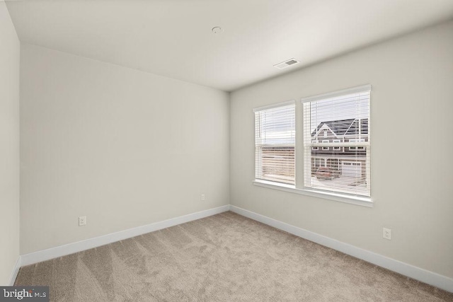 carpeted empty room with visible vents and baseboards