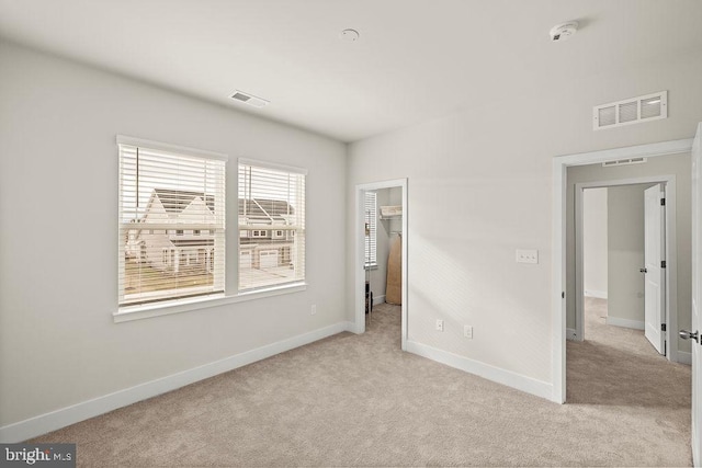 unfurnished bedroom featuring carpet, visible vents, and baseboards