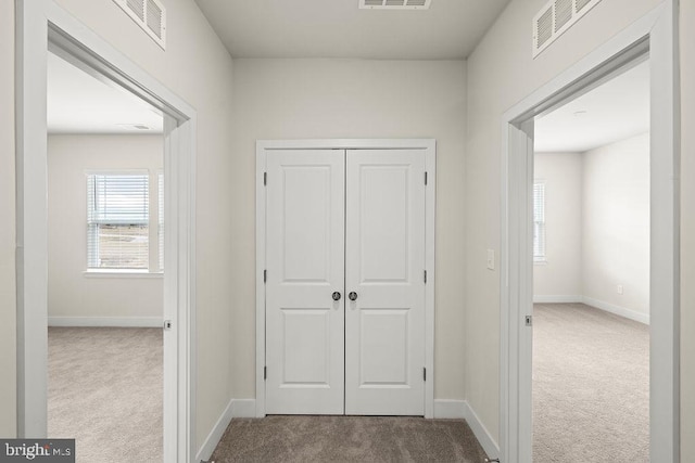 hall with carpet floors and visible vents