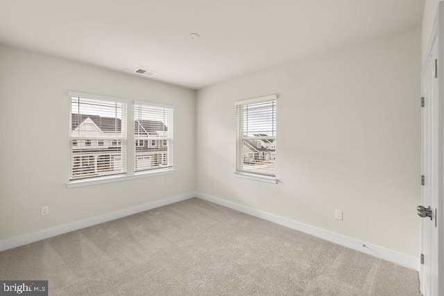 carpeted spare room with baseboards and visible vents