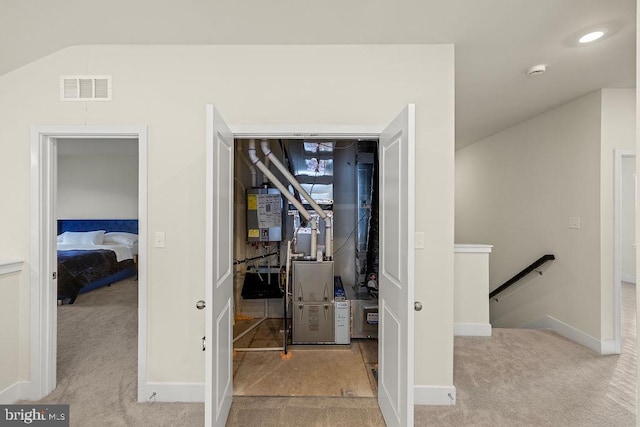 workout room with visible vents, baseboards, water heater, vaulted ceiling, and carpet