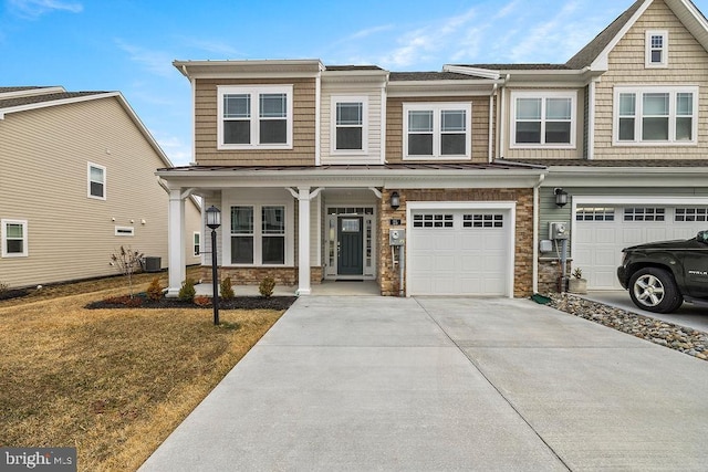 view of front of home with a garage, central AC unit, concrete driveway, stone siding, and a porch