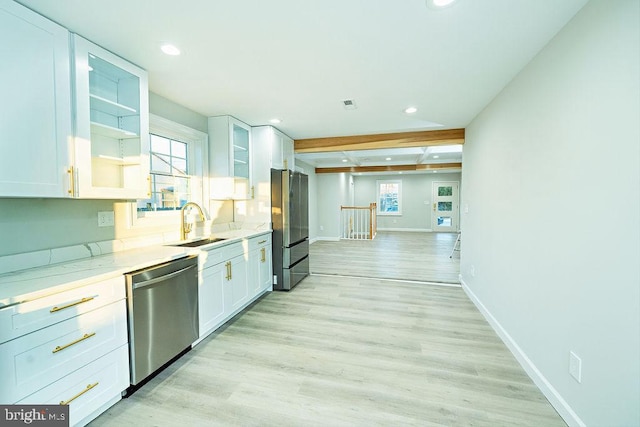 kitchen featuring appliances with stainless steel finishes, a wealth of natural light, white cabinetry, and light wood-style flooring