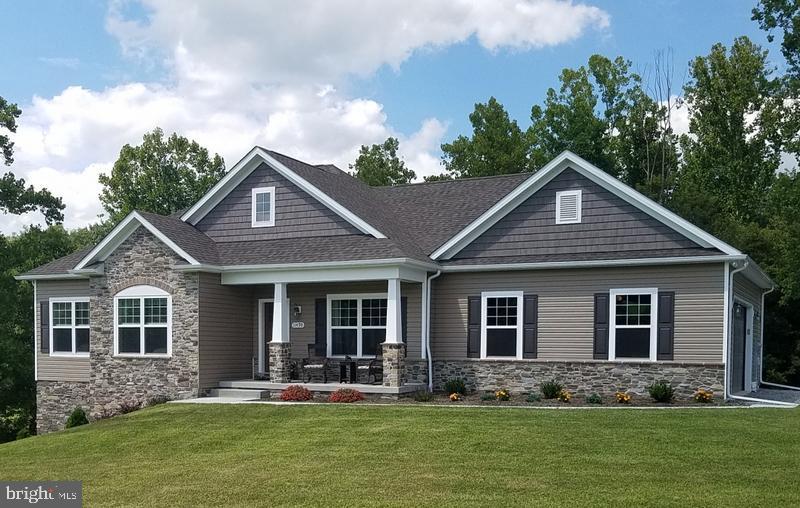 craftsman inspired home featuring stone siding, a front lawn, and a porch