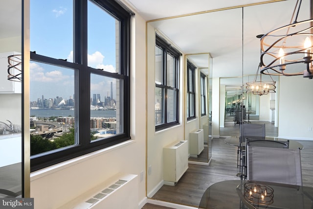 hall featuring a chandelier, a city view, a healthy amount of sunlight, and radiator