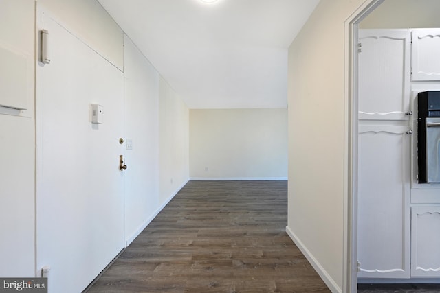 hall with dark wood finished floors and baseboards