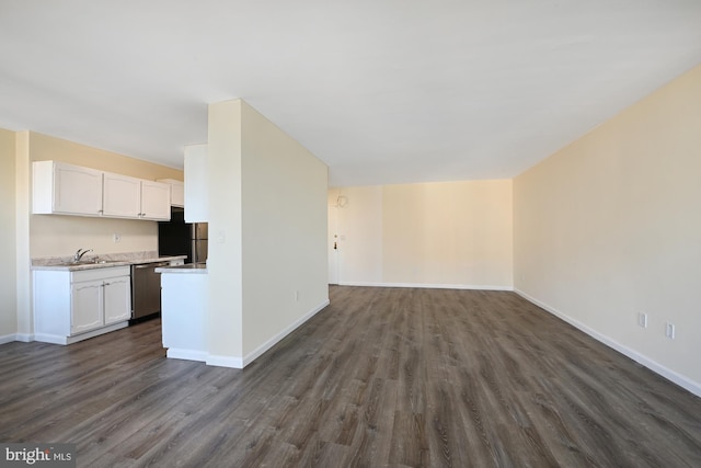 kitchen with dark wood-style flooring, stainless steel appliances, light countertops, open floor plan, and white cabinets