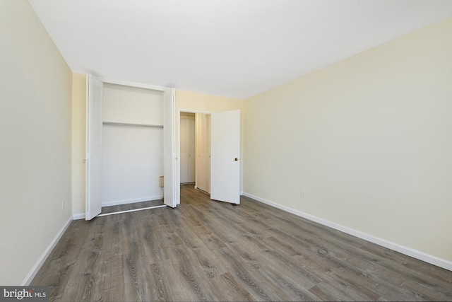 unfurnished bedroom featuring wood finished floors and baseboards