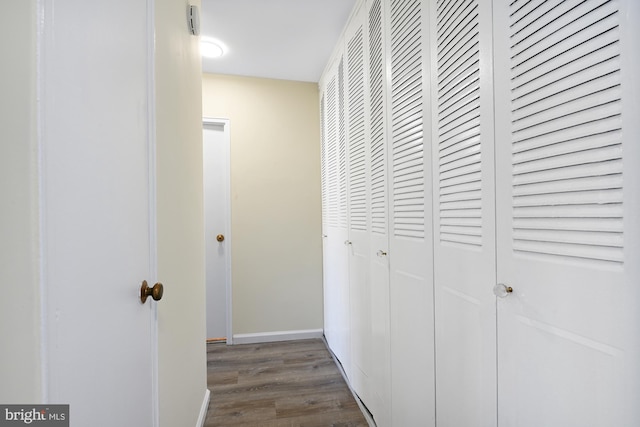 hallway featuring baseboards and wood finished floors