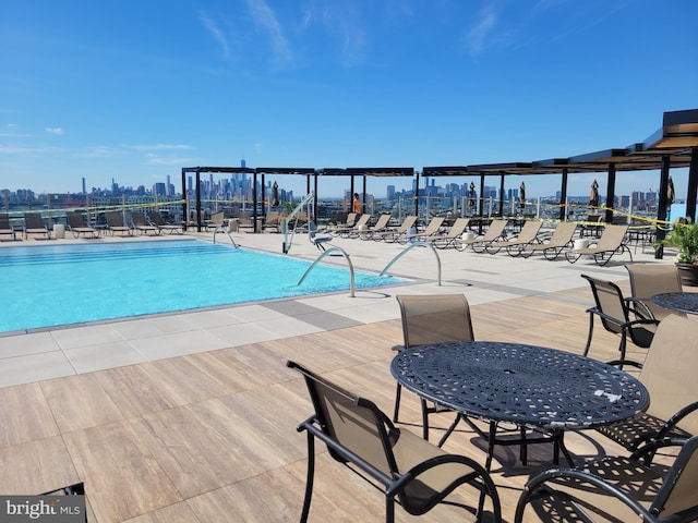 pool featuring a view of city, fence, and a patio