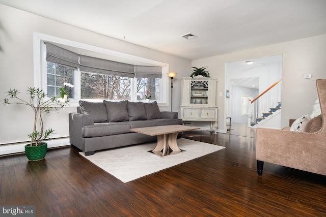 living room with stairs, wood-type flooring, and visible vents