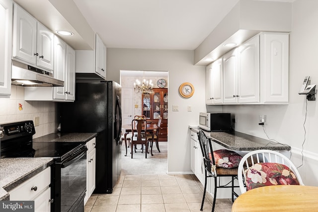 kitchen with white cabinetry, black appliances, backsplash, and under cabinet range hood