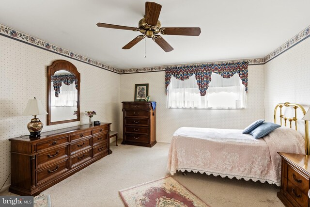 carpeted bedroom featuring a ceiling fan and wallpapered walls