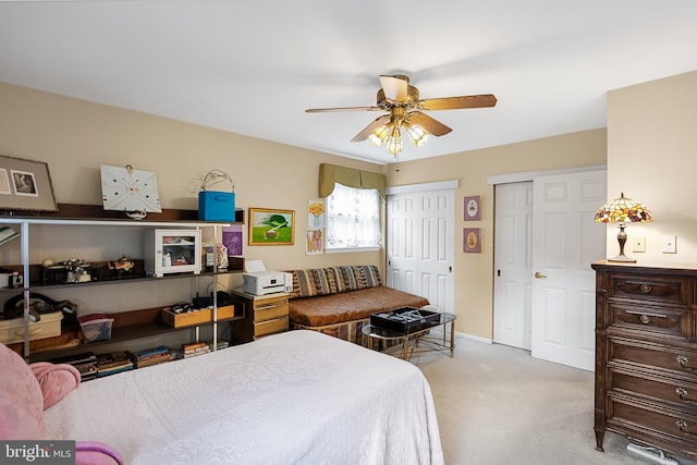 carpeted bedroom featuring baseboards, two closets, and a ceiling fan