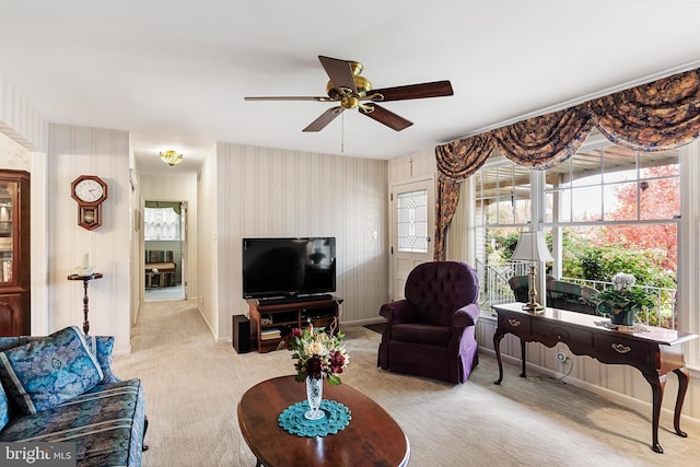 living room featuring baseboards, a ceiling fan, and carpet