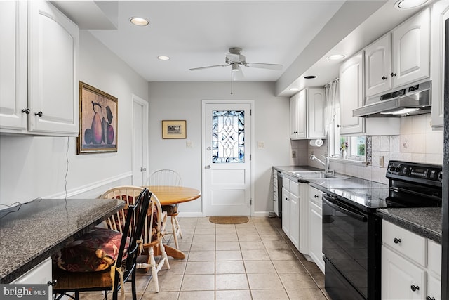 kitchen featuring backsplash, under cabinet range hood, electric range, white cabinetry, and a sink