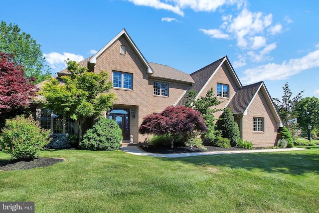 traditional-style house with brick siding and a front lawn