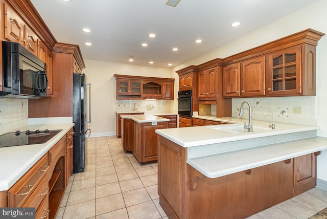 kitchen with glass insert cabinets, light tile patterned floors, a peninsula, black appliances, and a sink