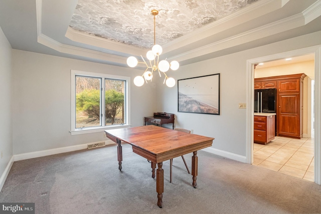 dining room with a raised ceiling, light colored carpet, visible vents, and baseboards