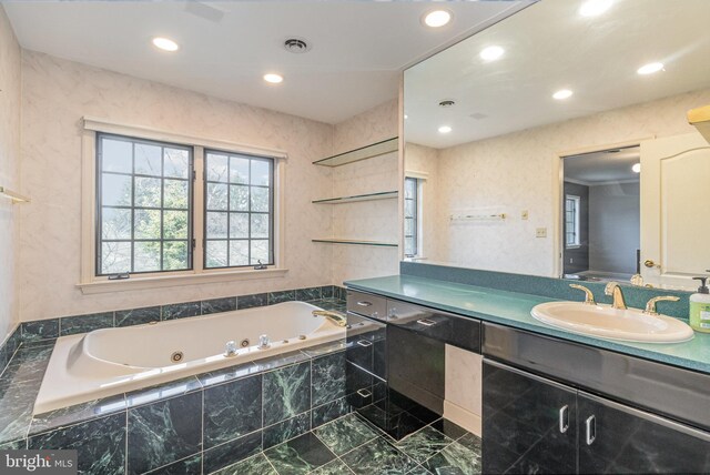 full bath featuring vanity, a jetted tub, recessed lighting, and visible vents