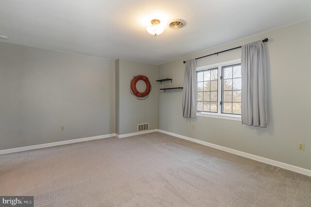 carpeted spare room with baseboards and visible vents