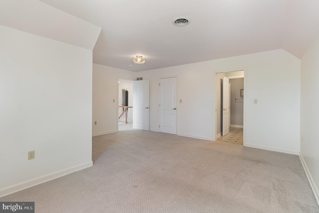 spare room featuring visible vents, baseboards, and light colored carpet