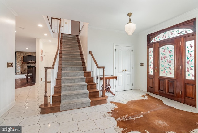 foyer with stairway, recessed lighting, a fireplace, and ornamental molding