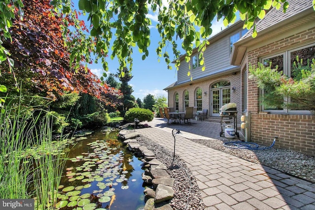 view of yard with a patio and a small pond