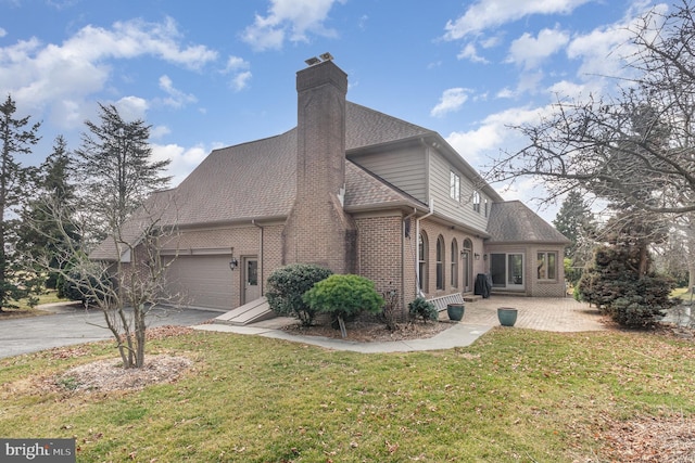 view of front of property with brick siding, a shingled roof, a front yard, a garage, and driveway