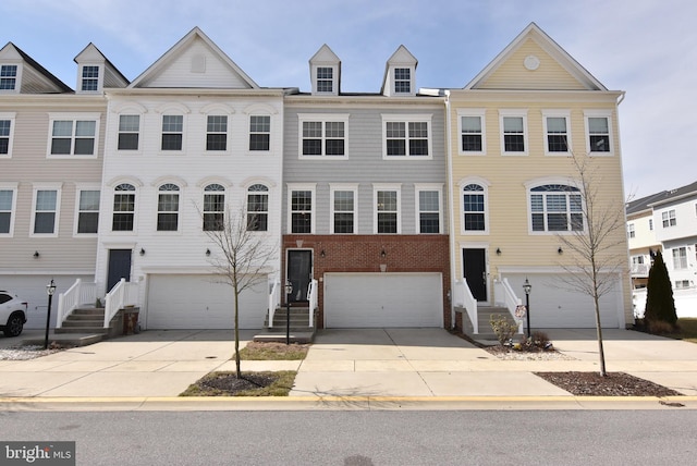 multi unit property featuring brick siding, an attached garage, and driveway