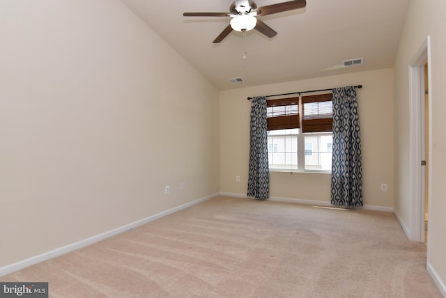 empty room featuring visible vents, light carpet, baseboards, and ceiling fan