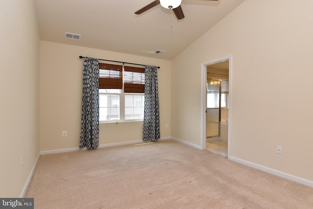 carpeted empty room featuring visible vents, baseboards, and vaulted ceiling