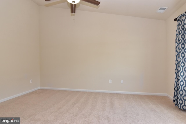 unfurnished room featuring light colored carpet, a ceiling fan, and baseboards