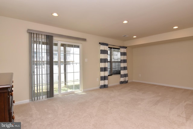 spare room featuring recessed lighting, visible vents, light carpet, and baseboards