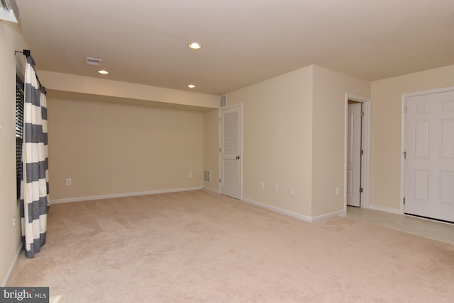 empty room featuring recessed lighting, light colored carpet, visible vents, and baseboards