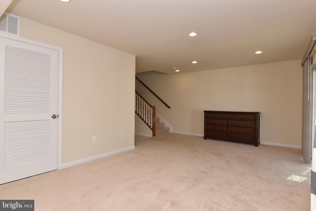 below grade area featuring visible vents, recessed lighting, stairway, carpet flooring, and baseboards