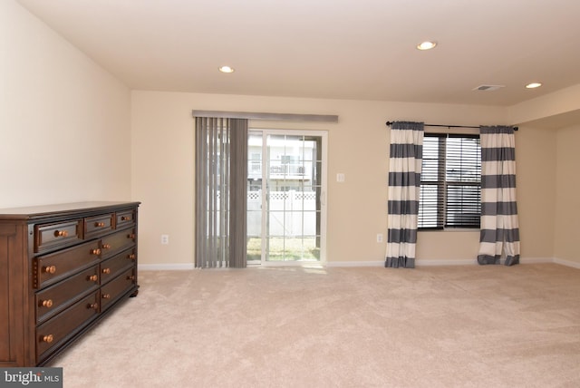 spare room featuring recessed lighting, baseboards, light carpet, and visible vents