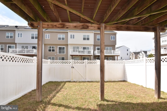 view of yard featuring a residential view, a fenced backyard, and a gate