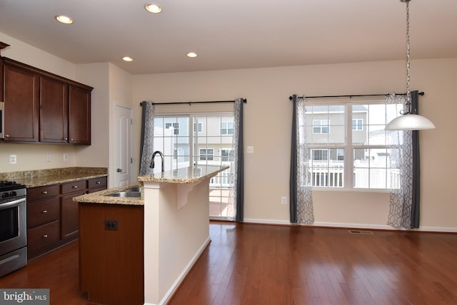 kitchen with a sink, stainless steel range with gas cooktop, a wealth of natural light, and dark wood-style flooring