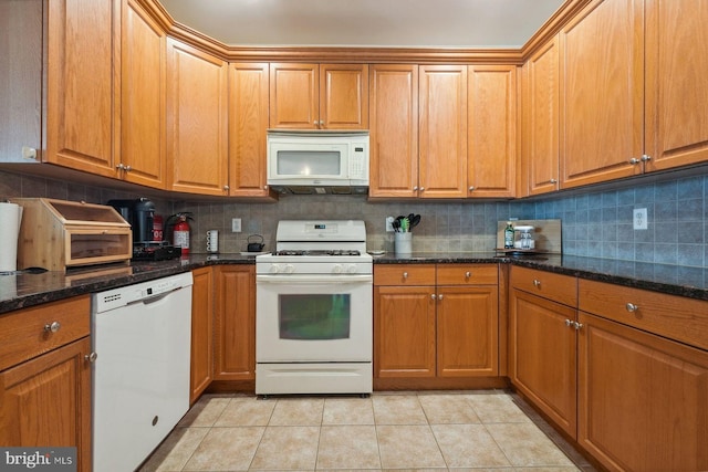 kitchen featuring light tile patterned floors, decorative backsplash, white appliances, and brown cabinetry